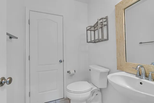 a bathroom with a toilet a sink and mirror