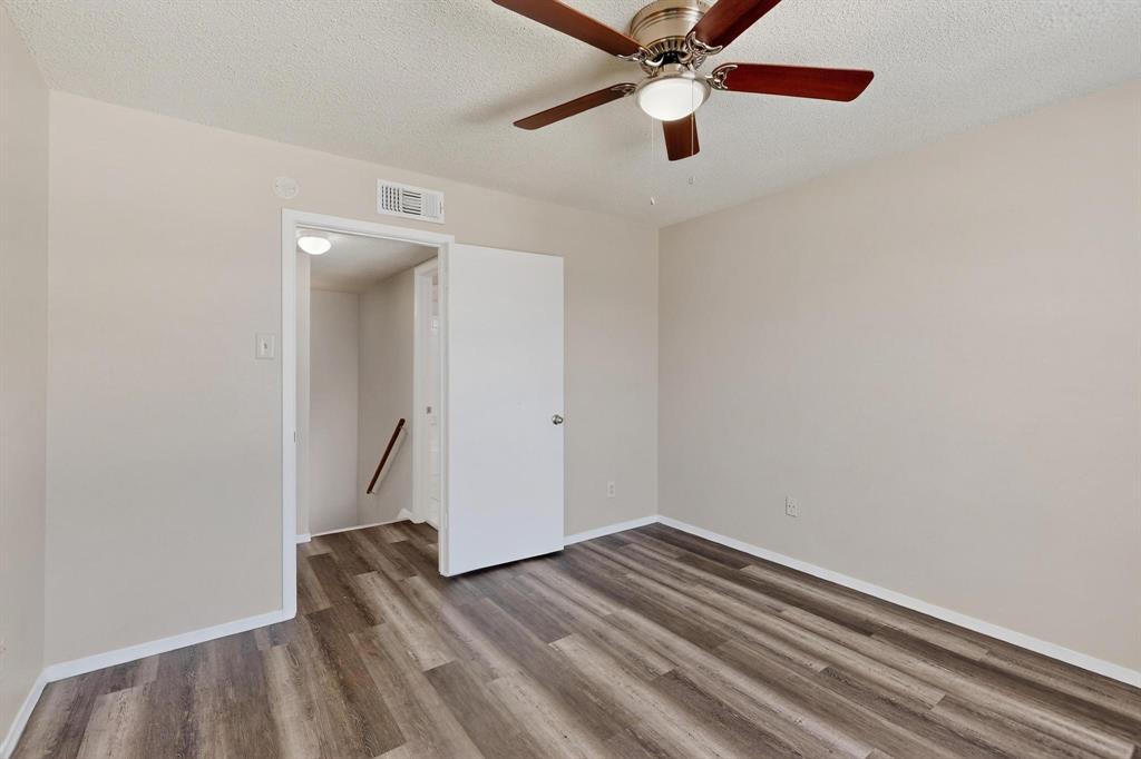 11311 Audelia Road, Unit 165 Dallas, TX 75243 - Photo 12 of 31 Empty room featuring a textured ceiling, ceiling fan, and wood finished floors