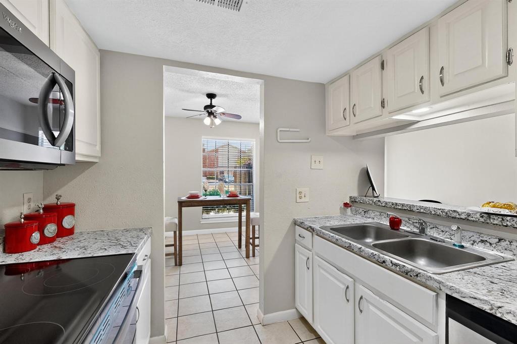11311 Audelia Road, Unit 165 Dallas, TX 75243 - Photo 2 of 31 Kitchen featuring a textured ceiling, appliances with stainless steel finishes, ceiling fan, white cabinetry, and light tile patterned floors