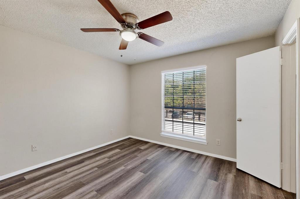 11311 Audelia Road, Unit 165 Dallas, TX 75243 - Photo 22 of 31 Unfurnished room with a textured ceiling, dark wood-style flooring, and ceiling fan
