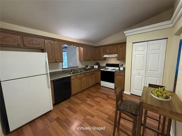 a kitchen with granite countertop stainless steel appliances a refrigerator a stove a sink a dining table and chairs