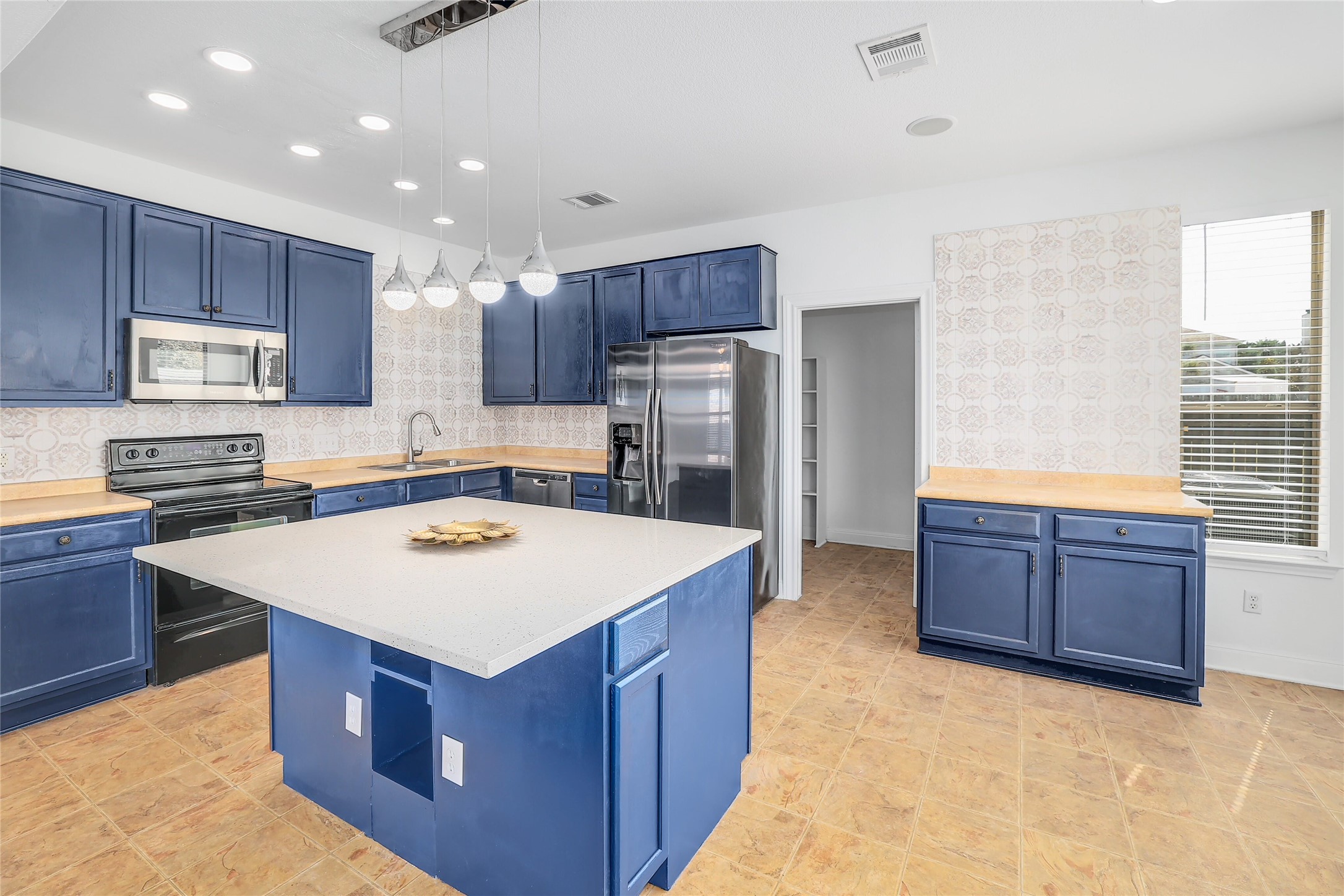 203 Ran Road Leander, TX 78641 - Photo 4 of 31 Gleaming stone countertops and matching cabinetry surround a central prep island in this well-appointed kitchen.