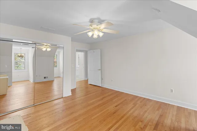 a view of a room with wooden floor and a ceiling fan