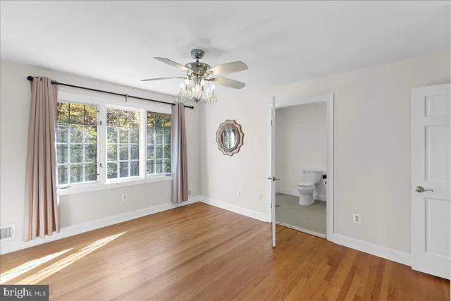 a bathroom with a granite countertop sink a toilet a mirror and shower