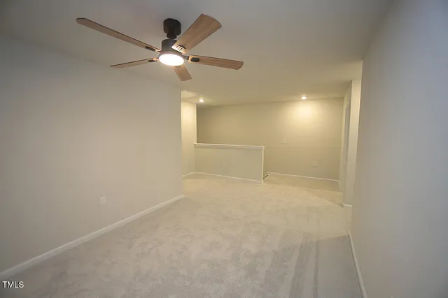 en empty room with ceiling fan and window