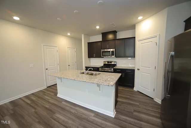 a kitchen with stainless steel appliances a refrigerator and a stove top oven