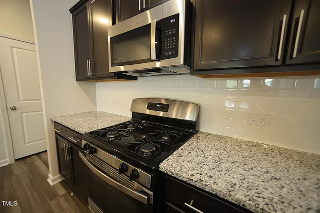 a kitchen with wooden cabinets and a stove top oven