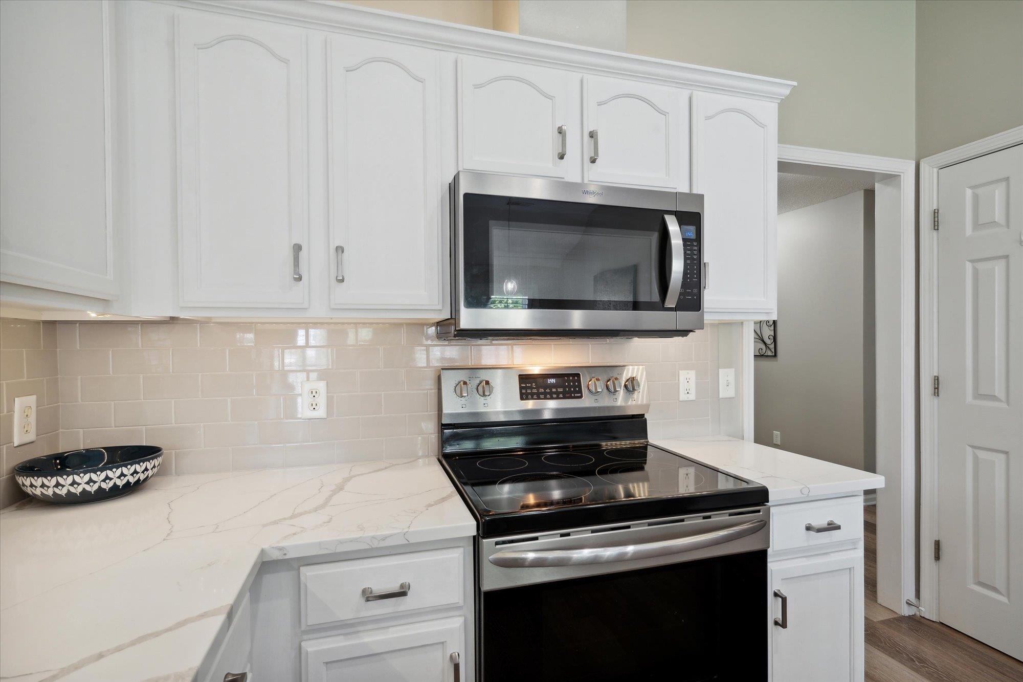448 Queens Bridge Road Collierville, TN 38017 - Photo 13 of 32 a kitchen with cabinets stainless steel appliances and a wooden floor