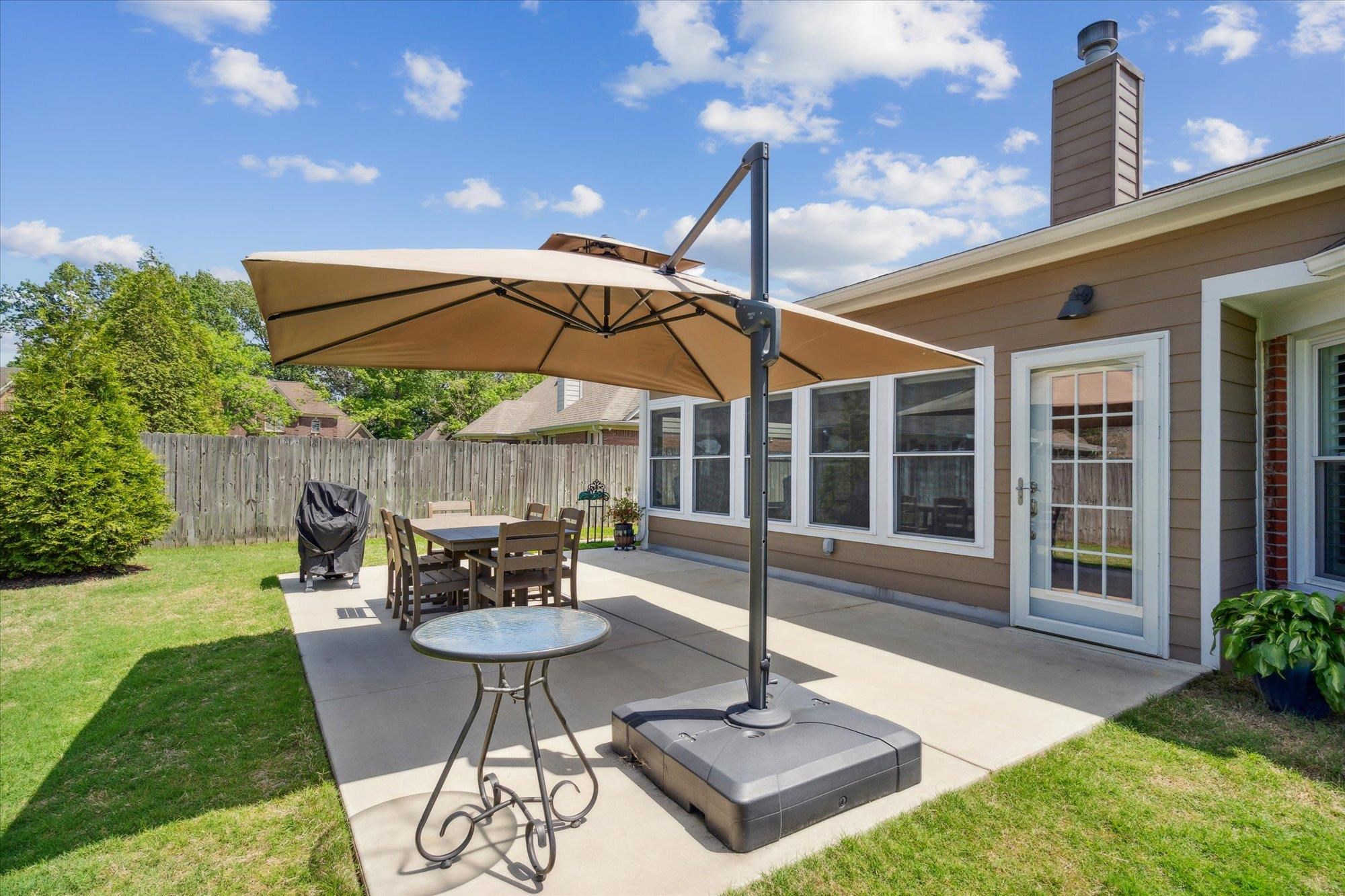 448 Queens Bridge Road Collierville, TN 38017 - Photo 29 of 32 a view of a patio with a table and chairs under an umbrella