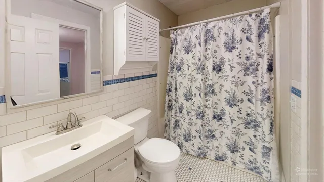 a bathroom with a sink a toilet and a mirror