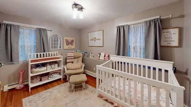 a room with lots of white furniture and wooden floor