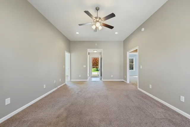 an empty room with fan and windows