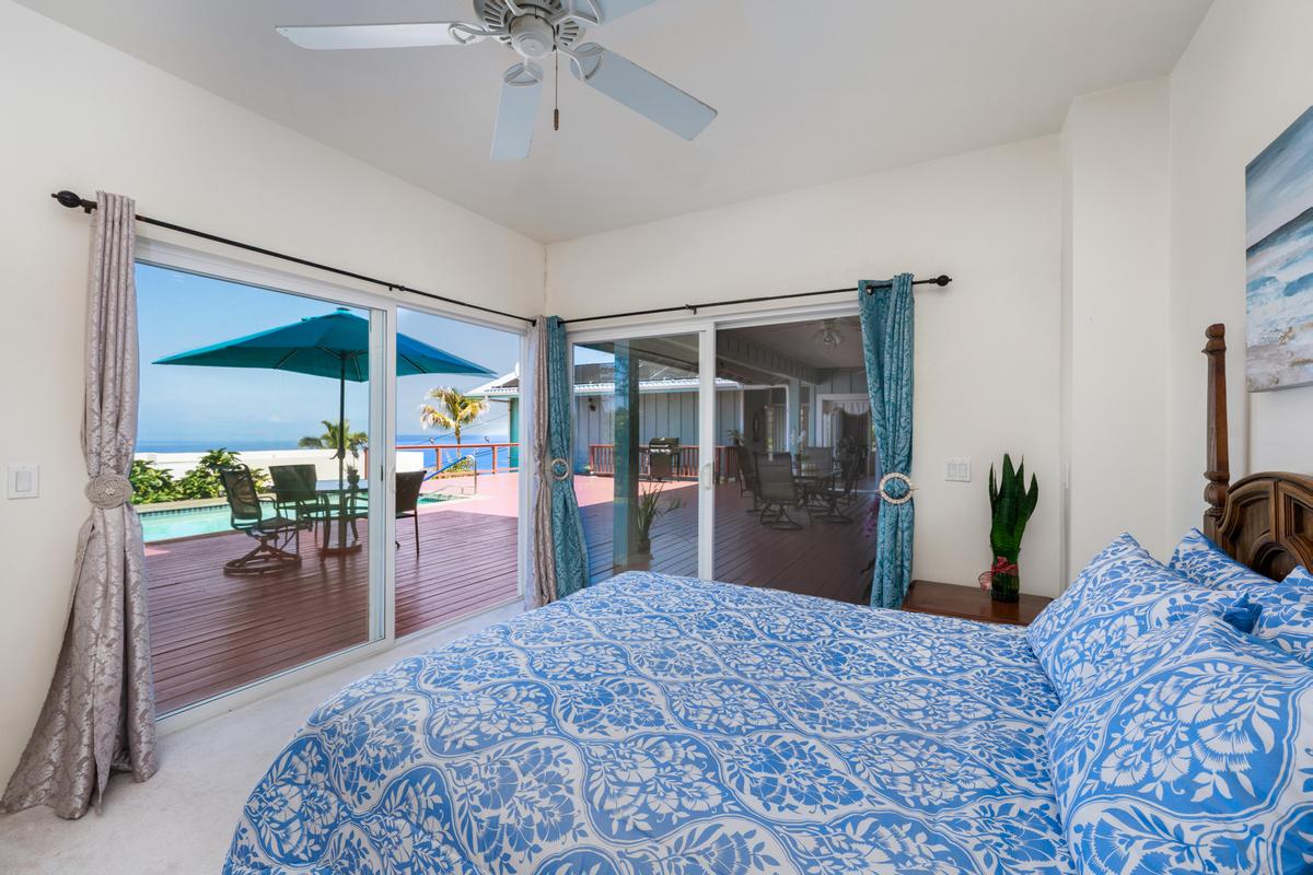 87-404 Kaohe Road Captain Cook, HI 96704 - Photo 20 of 25 a bedroom with a bed and ceiling fan