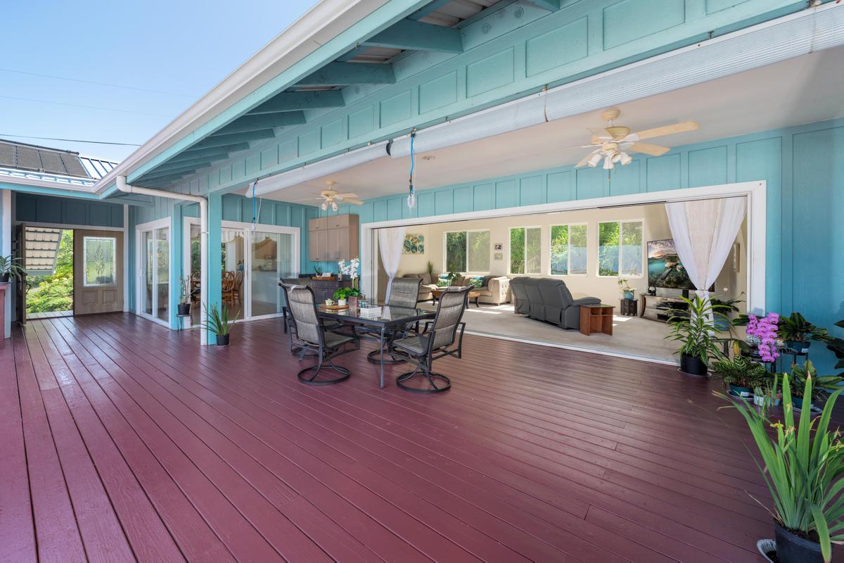 87-404 Kaohe Road Captain Cook, HI 96704 - Photo 2 of 25 a view of a patio with table and chairs potted plants with wooden floor