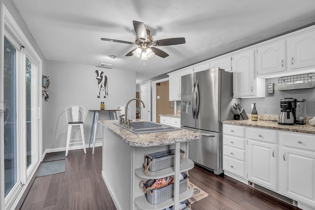 91 Chapin Road Hudson, MA 01749 - Photo 11 of 42 a kitchen with stainless steel appliances granite countertop a refrigerator a sink dishwasher a stove and white countertops with wooden floor