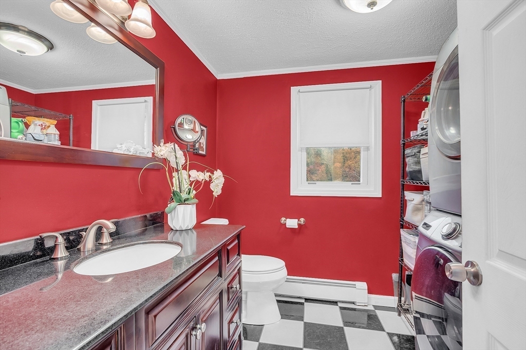 91 Chapin Road Hudson, MA 01749 - Photo 20 of 42 a bathroom with a granite countertop toilet a sink and a mirror