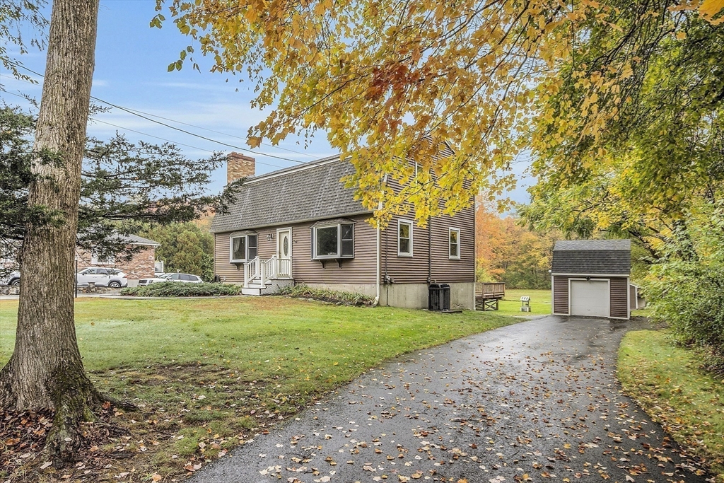 91 Chapin Road Hudson, MA 01749 - Photo 2 of 42 a front view of a house with a garden and trees