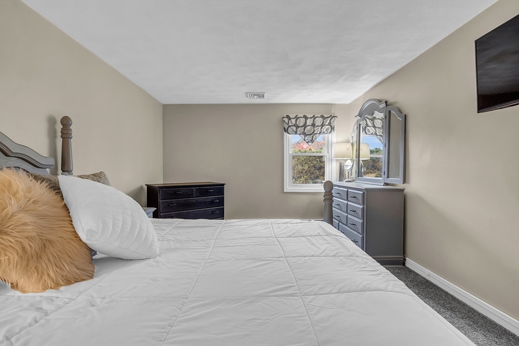 91 Chapin Road Hudson, MA 01749 - Photo 23 of 42 a bedroom with a bed and a flat screen tv
