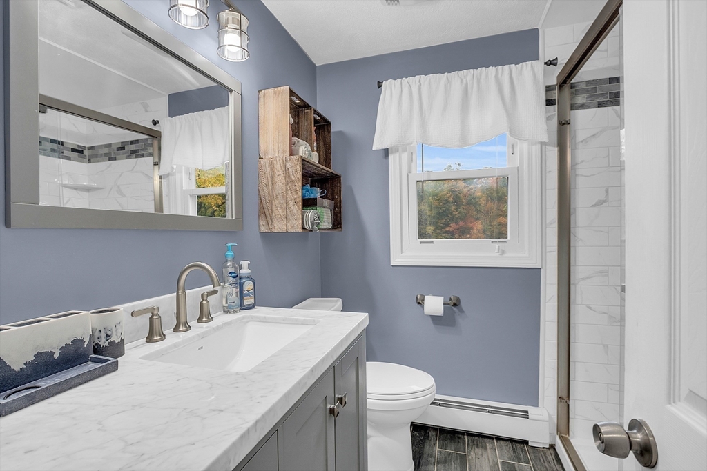 91 Chapin Road Hudson, MA 01749 - Photo 24 of 42 a bathroom with a granite countertop sink mirror vanity and toilet