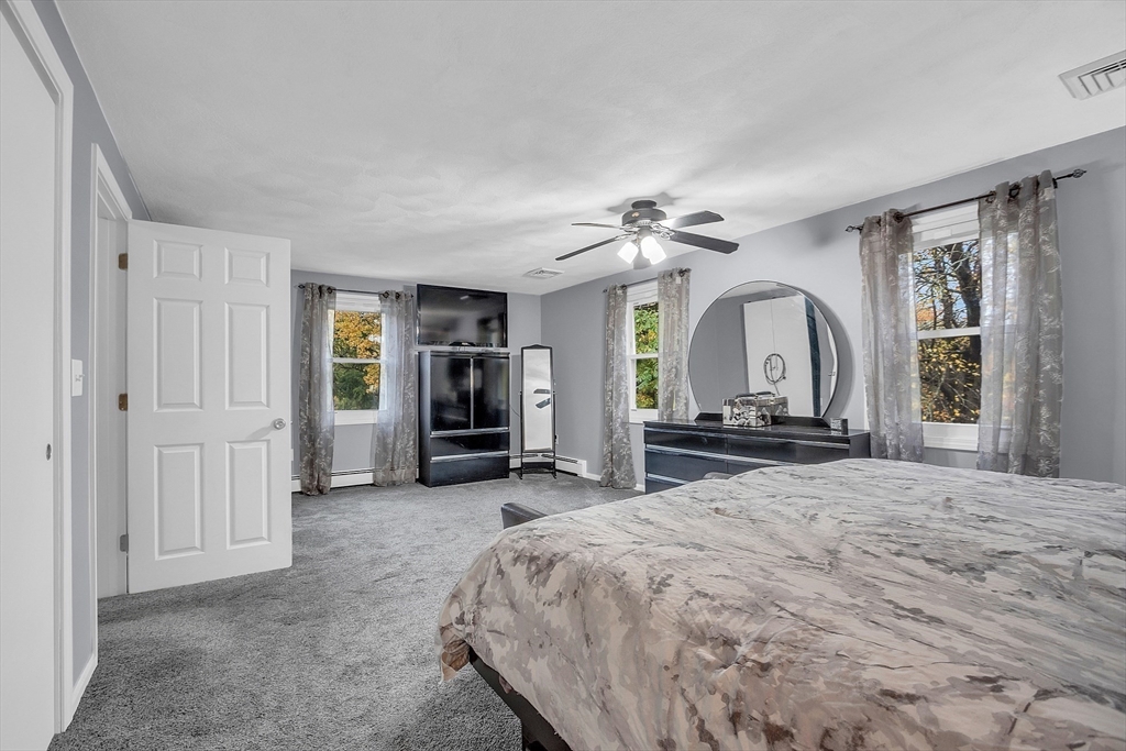 91 Chapin Road Hudson, MA 01749 - Photo 26 of 42 a spacious bedroom with a bed a table and large mirror