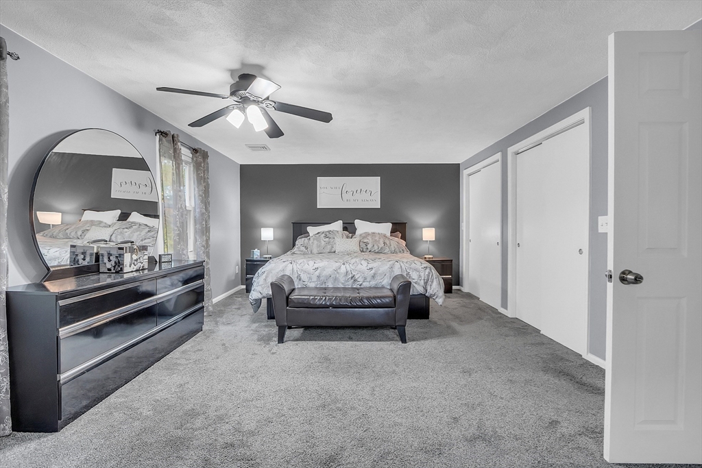 91 Chapin Road Hudson, MA 01749 - Photo 27 of 42 a spacious bedroom with a bed and a chandelier