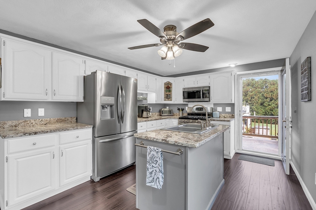 91 Chapin Road Hudson, MA 01749 - Photo 5 of 42 a kitchen with granite countertop stainless steel appliances a stove top oven a refrigerator a sink dishwasher and white cabinets with wooden floor