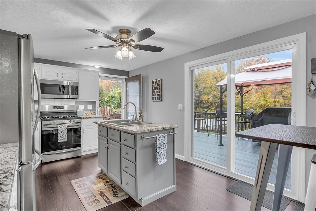 91 Chapin Road Hudson, MA 01749 - Photo 6 of 42 a kitchen with stainless steel appliances granite countertop a stove top oven a sink dishwasher a dining table and chairs with wooden floor