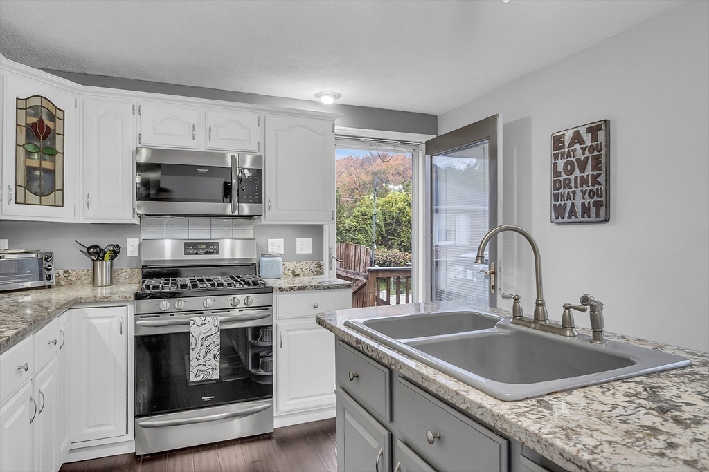 91 Chapin Road Hudson, MA 01749 - Photo 8 of 42 a kitchen with granite countertop a stove a sink and a microwave