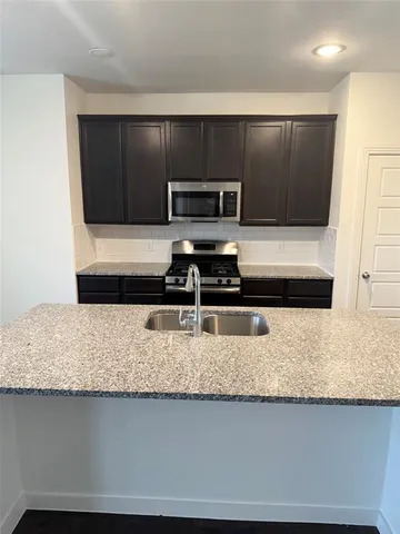 a kitchen with sink cabinets and stainless steel appliances