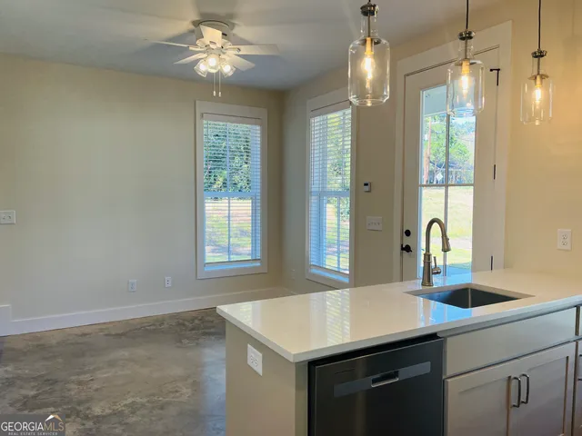a kitchen with a sink dishwasher a dining table and chairs