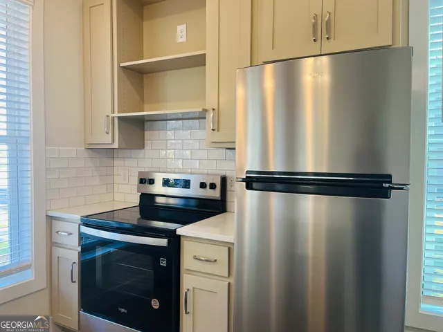 a close view of a stove top oven and refrigerator
