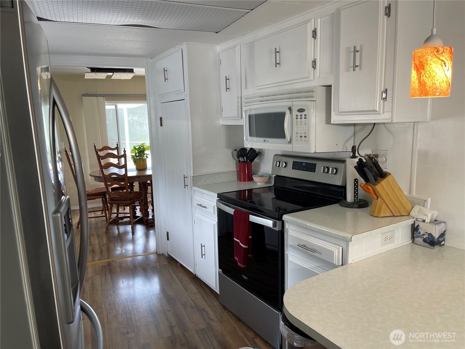 2101 South 324th Street, Unit 21 Federal Way, WA 98003 - Photo 14 of 40 a kitchen with stainless steel appliances a stove a refrigerator a dining table and chairs