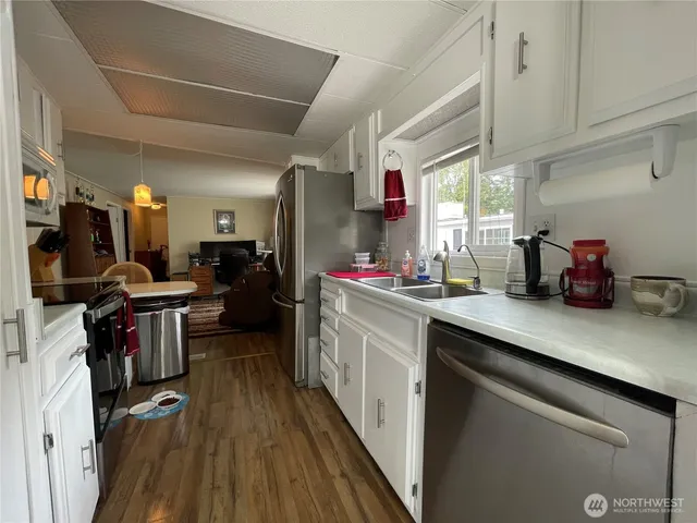 a kitchen with sink refrigerator and cabinets