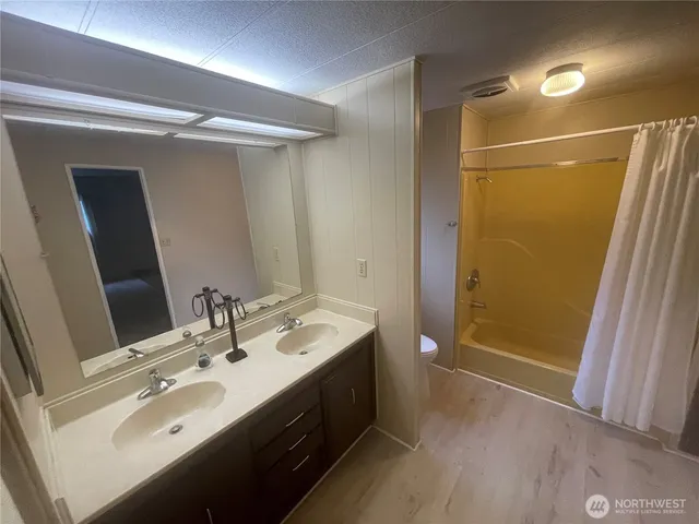 a bathroom with a double vanity sink a large mirror and shower