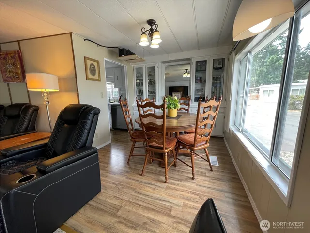 a dining room with furniture a chandelier and wooden floor
