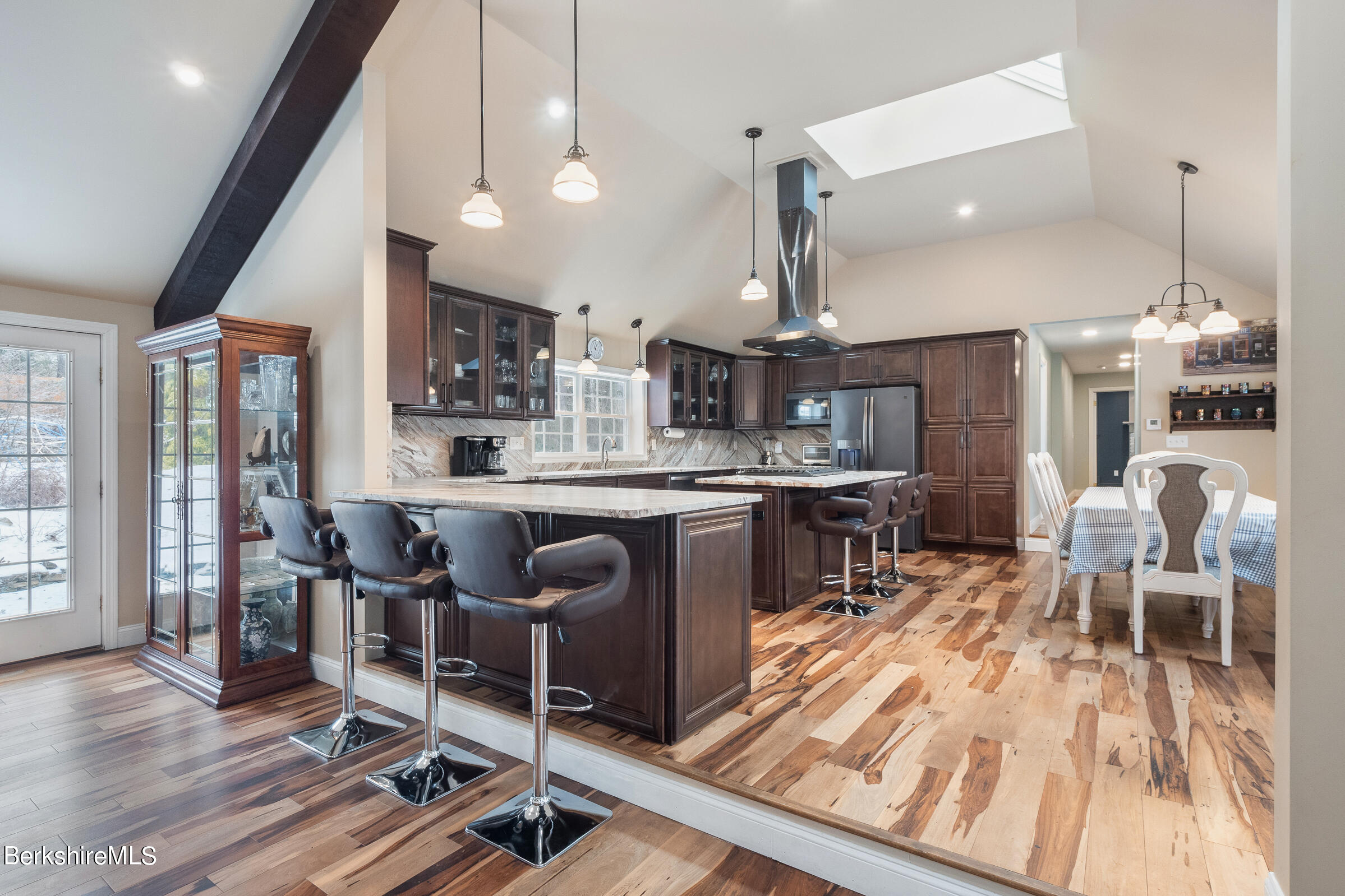 7 Hawthorne Road Stockbridge, MA 01262 - Photo 14 of 41 a kitchen with stainless steel appliances kitchen island granite countertop a stove a refrigerator a sink a dining table and chairs with wooden floor