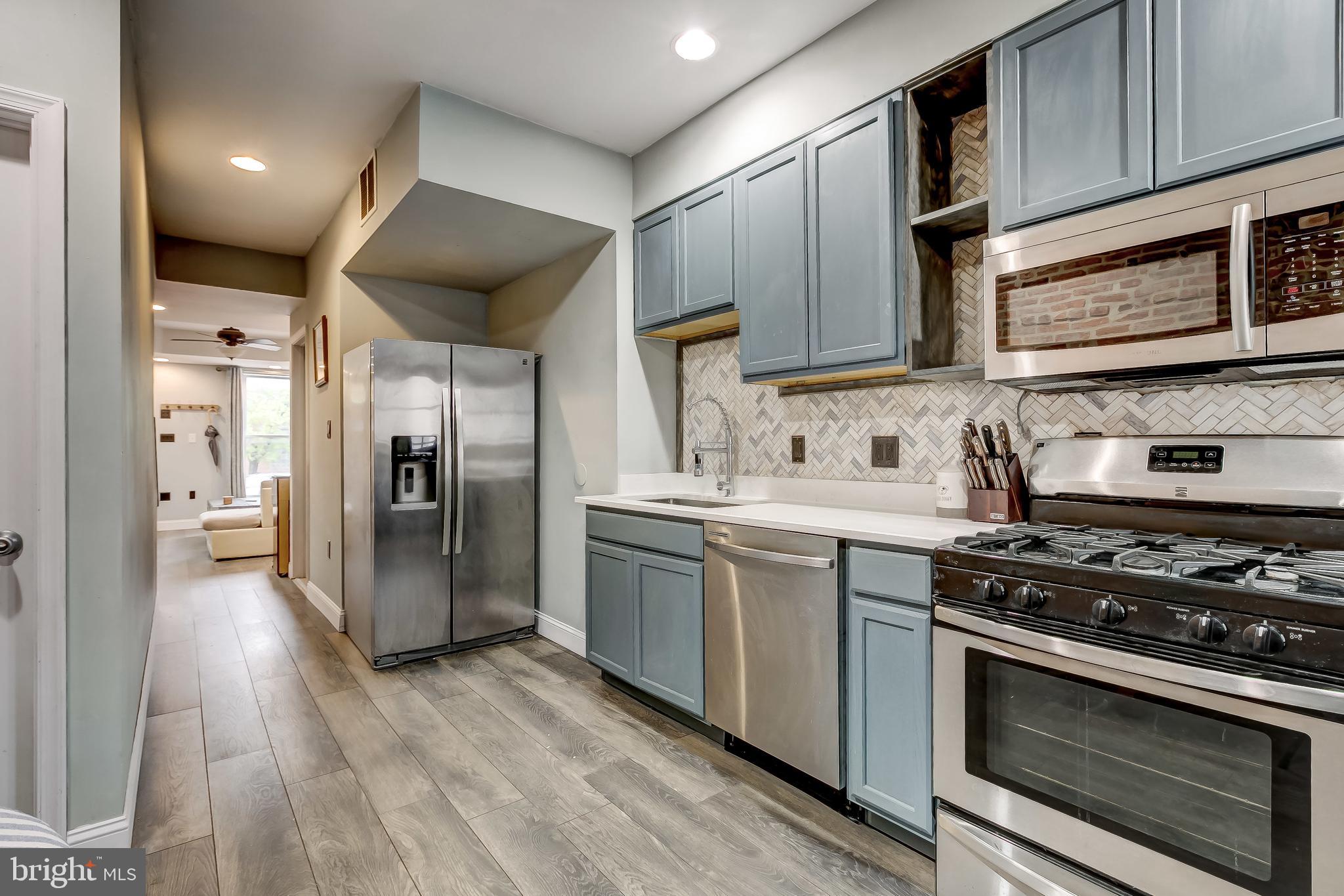 1404 Decatur Street Baltimore, MD 21230 - Photo 12 of 29 a kitchen with stainless steel appliances granite countertop a stove a refrigerator and a microwave