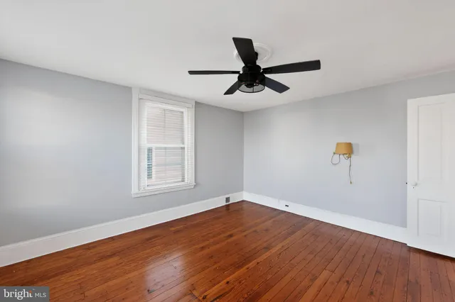 a view of a big room with wooden floor and windows