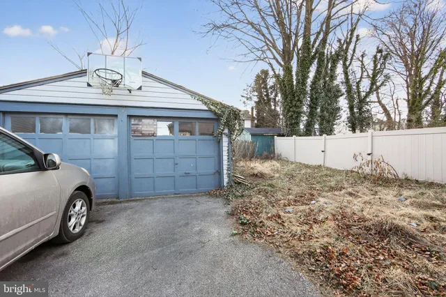 a view of a garage and a car parked in a yard