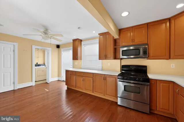 a kitchen with granite countertop stainless steel appliances and wooden cabinets