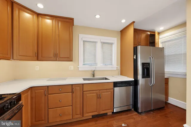 a kitchen with a sink a refrigerator and cabinets