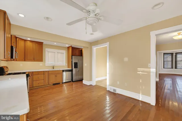 a large kitchen with a wooden floor and a large window
