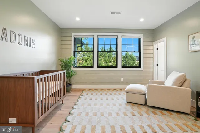 a hallway with white cabinets and wooden floor