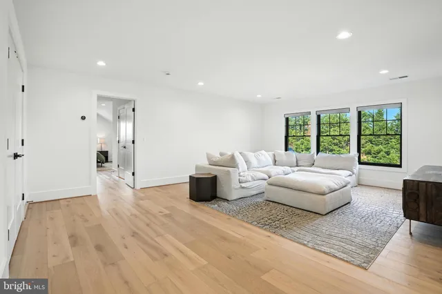 a view of a white house next to a yard with big trees