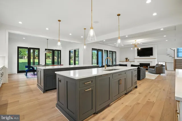 a kitchen with stainless steel appliances granite countertop a sink a stove and a wooden floors