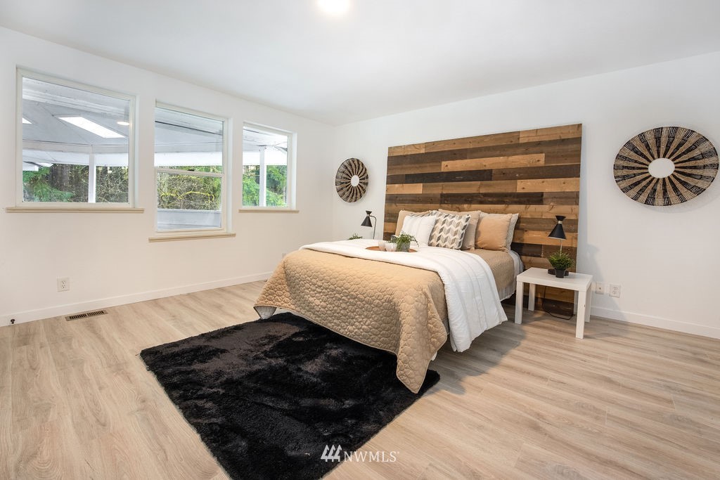 12425 Highway 12 Rochester, WA 98579 - Photo 12 of 29 a bedroom with a bed and wooden floor