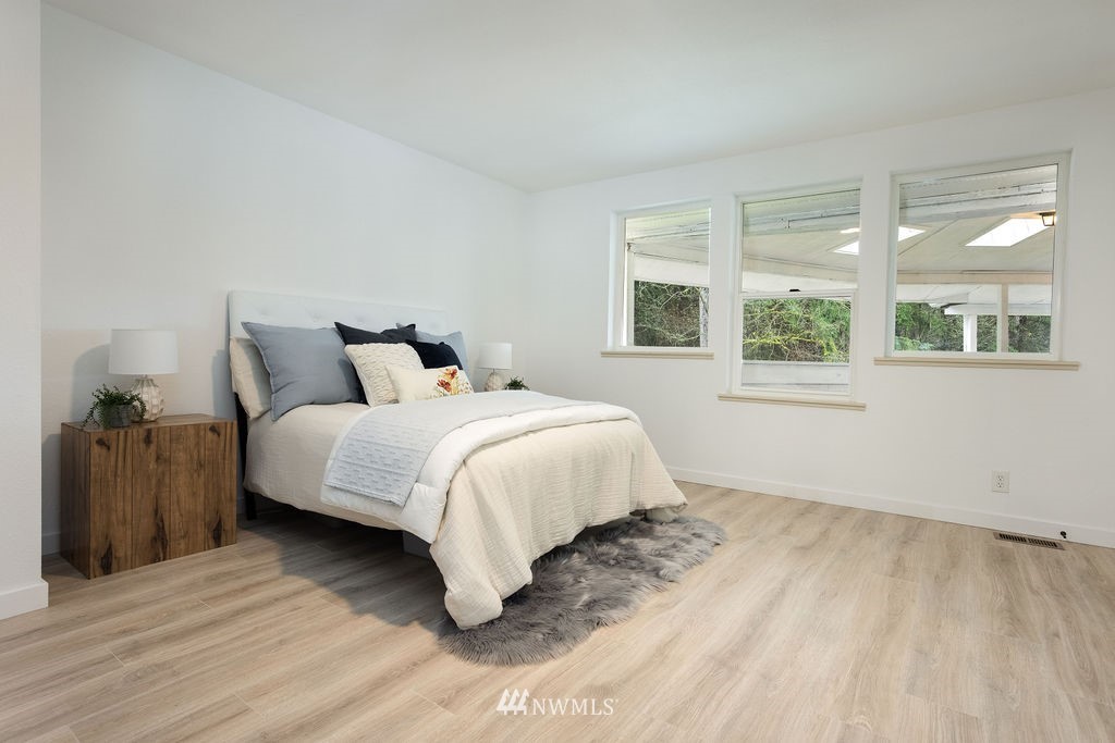 12425 Highway 12 Rochester, WA 98579 - Photo 16 of 29 a bedroom with a bed and wooden floor