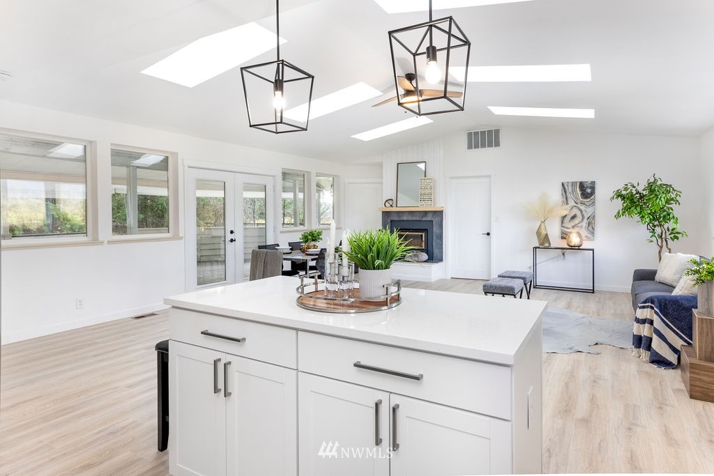 12425 Highway 12 Rochester, WA 98579 - Photo 9 of 29 a kitchen with a table a chandelier and wooden floor