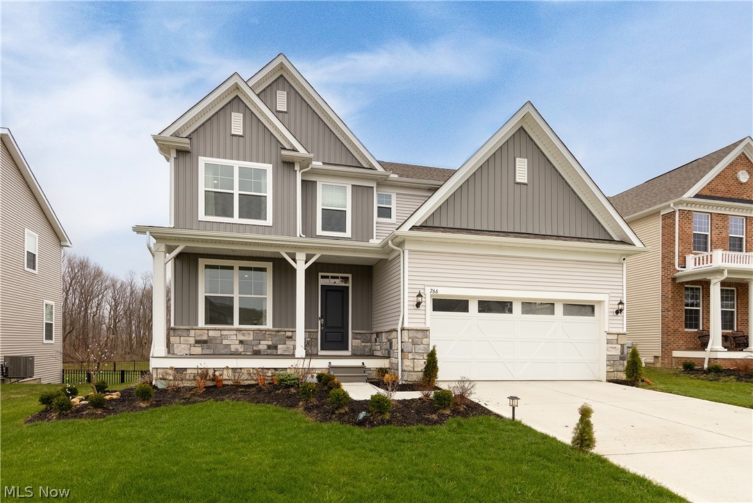 766 River Run Road Aurora, OH 44202 - Photo 1 of 49 Craftsman inspired home featuring board and batten siding, a porch, driveway, stone siding, and an attached garage