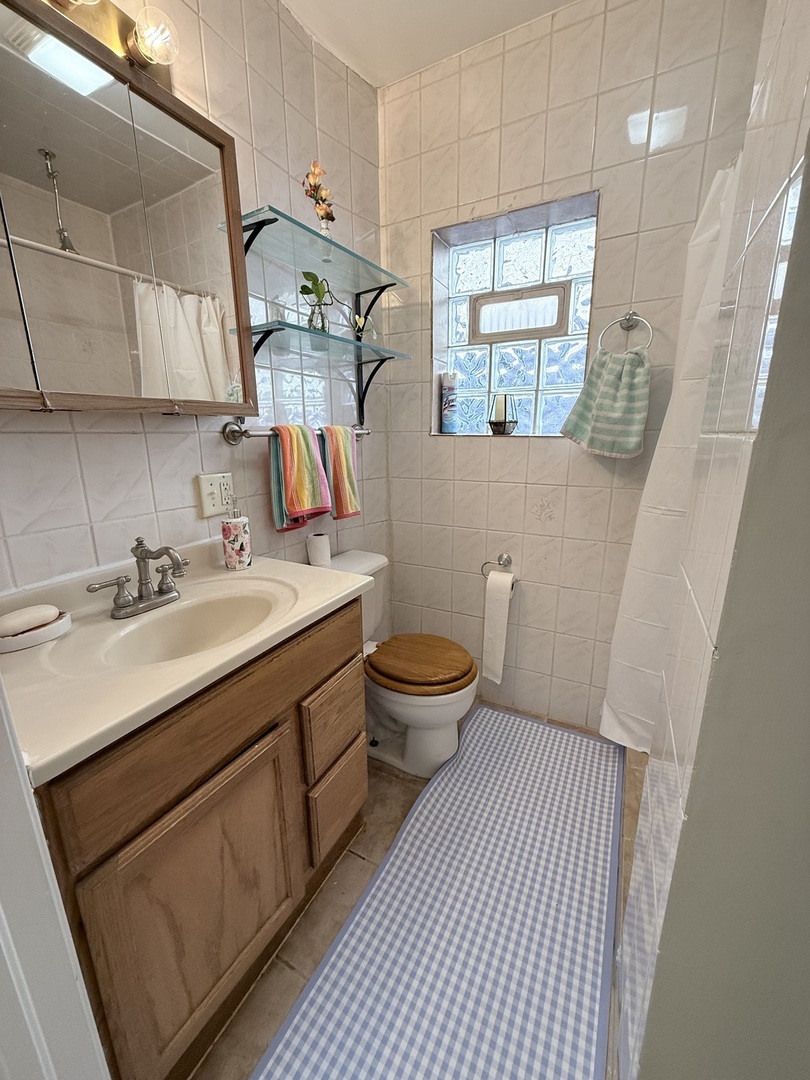 3643 South Hamilton Avenue, Unit 3 Chicago, IL 60609 - Photo 21 of 29 a bathroom with a sink mirror toilet and window